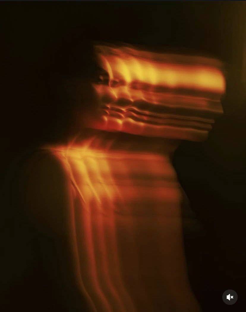 Silueta femenina atravesada por luz cálida
